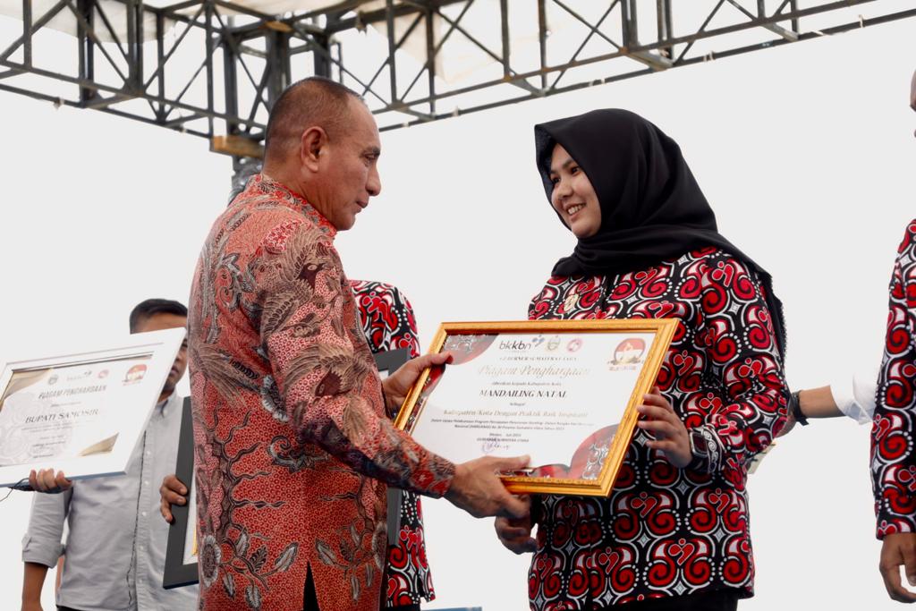 Teks foto beritasore/Ist Gubernur Sumut Edy Rahmayadi menyerahkan penghargaan mendapat dari BKKBN Sumut kepada Wabup Madina Atika Azmi Utammi Nasution.