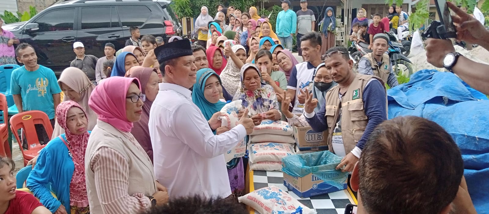 Teks fhoto: Dewan Pendiri sekaligus Pembina Komunitas Sedekah Jum'at (KSJ) yang akrab disapa Polisi Sang Pejuang Dhuafa Kombes Pol (Purn) H.Ikhwan Lubis SH,MH terus dan terus menyantuni 20 orang anak Yatim/Piyatu dan 60 orang Dhuafa sekaligus membuka pasar murah sembako beras kemasan isi 5 Kg seharga Rp.50.000- didepan rumah Uden Dusun II Desa Kuala Sikasim Kecamatan Sei Balai Kabupaten Batu Bara Jum'at (01/9-1023). beritasore/alirsyah