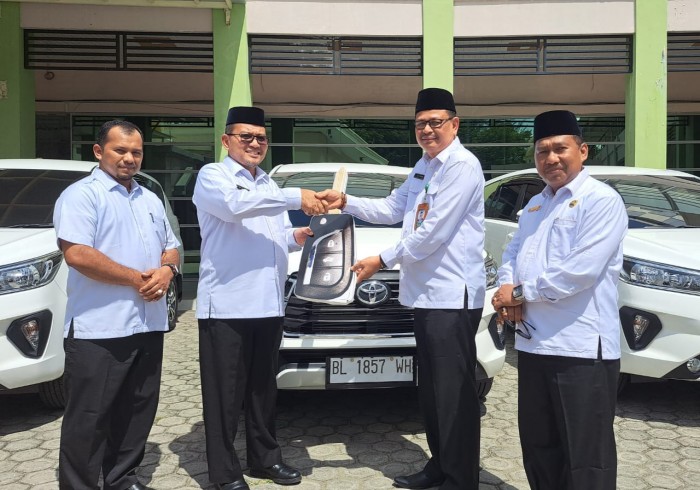 Teks foto: Kakanwil Kemenag Aceh Azhari (kiri) menyerahkan tiga unit bantuan mobil dinas dijajaran Kanwil Kemenag, berlangsung dihalaman kantor kanwil setempat, Senin (18/09/23). (T.Mansursyah)