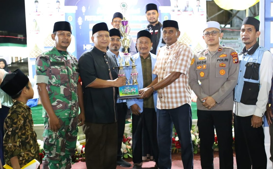 SERAHKAN TROPI: Camat Peureulak Barat, Murdhani, didampingi unsur muspika lainnya dan pengurus BKPRMI menyerahkan Tropi Juara Umum diterima Keuchik Gampong Beusa Seubrang, dalam pengumuman dan penutupan FASI ke-II DPK BKPRMI Peureulak Barat, Aceh Timur, Rabu (28/9) malam. (Ist).