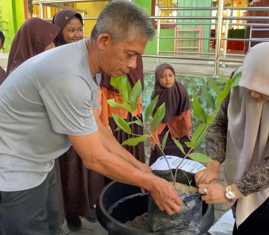 Kadis Lingkungan Hidup Aceh Besar, Muward,i SH bersama Kepala SDN 1 Pagar Air, Dewi Sulastri Melakukan Penanaman Perdana di lingkungan sekolah setempat, Sabtu (30/9). (Foto: Zafrullah)