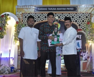 Teks foto : Pj Bupati Aceh Tamiang Meurah Budiman saat menyerahkan piala dan penghargaan kepada pemenang juara I Dalail Khairat.