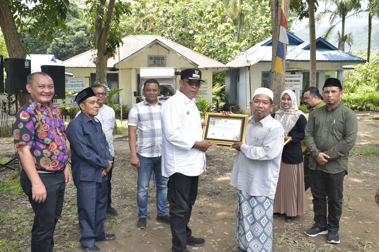 Teks foto: Bupati Madina HM Jafar Sukhairi Nasution menyerahkan bantuan ekonomi produktif dan piagam partisipasi proklim di desa penyangga TNBG. beritasore/Irham H. Nasution