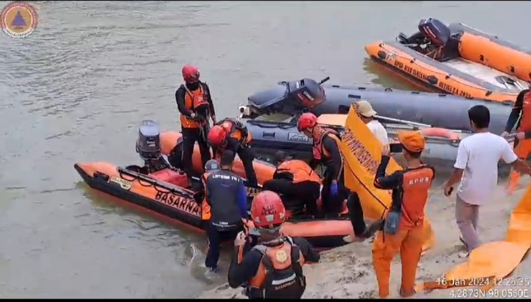 Teks foto : Personil BPBD dibantu TNI/Polri dan masyarakat membantu evakuasi korban dari sungai Tamiang.