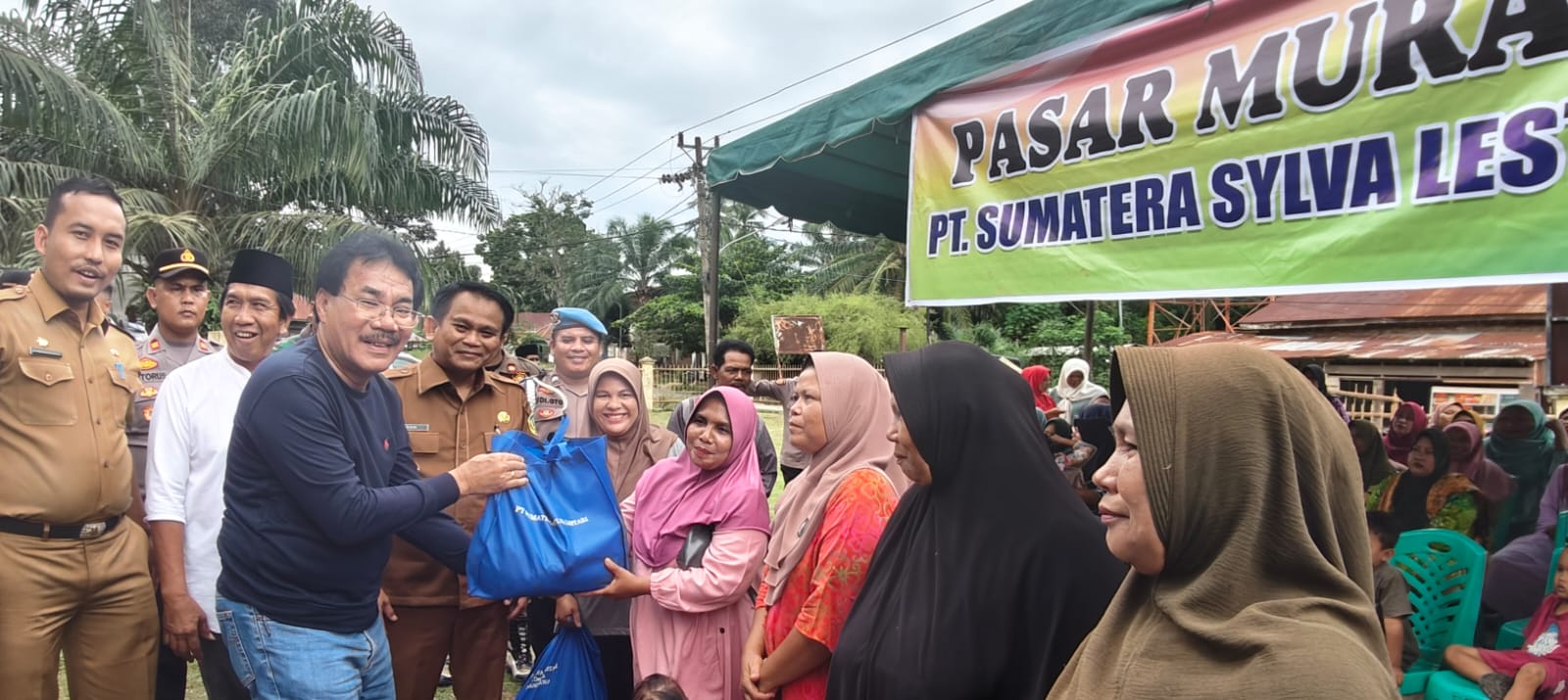 Keterangan Gambar: Komisaris PT SSL, Muller Tampubolon disaksikan Pj Bupati Palas,Ir. Ardan Noor Hasibuan MM, menyerahkan paket sembako kepada masyarakat di Kecamatan Huristak, Selasa (10/9) (Berita/Ist)