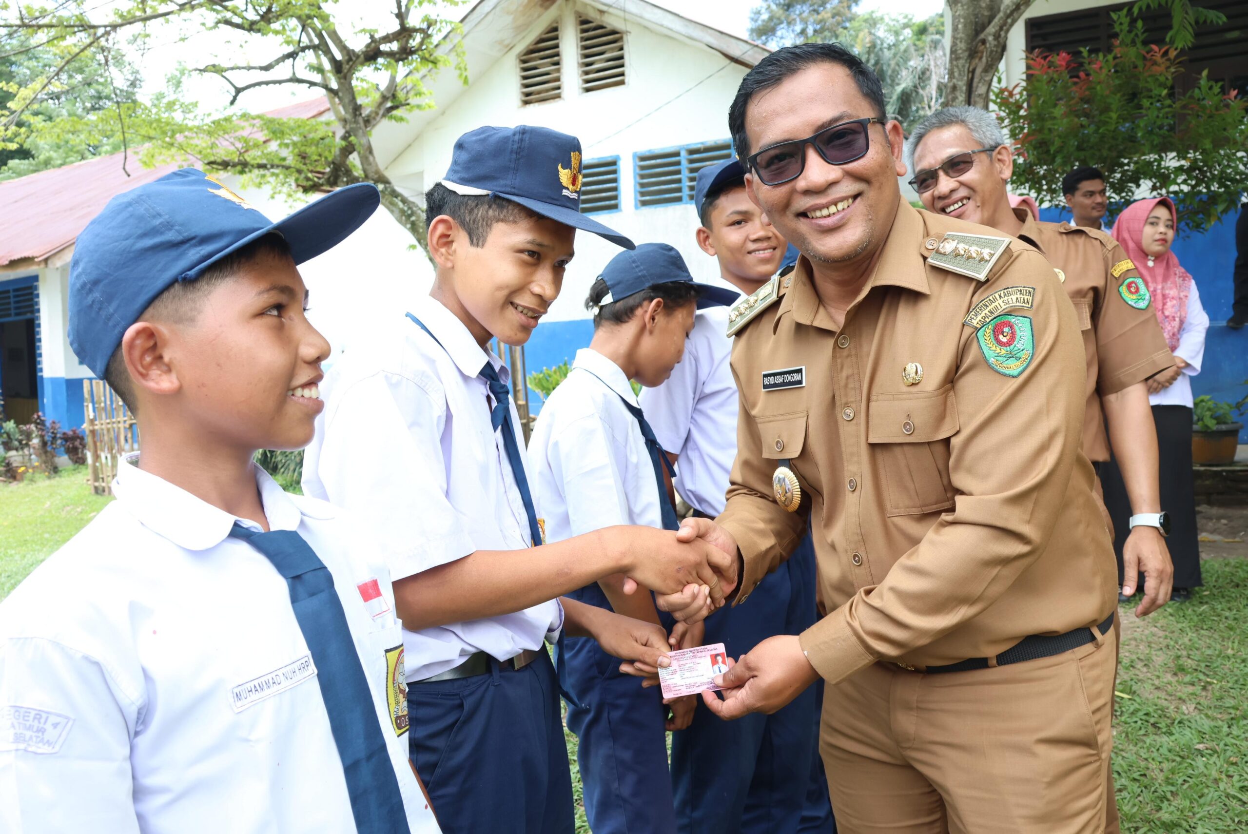 Berita Sore/Birong RT Teks poto: Plt Bupati Tapanuli Selatan Rasyid Assaf Dongoran saat membagikan Kartu Indentitas Anak (KIA) bagi pelajar SD, SMP di Kelurahan Batangtura Sirumambe Kec.Angkola Timur, Senin (30/9/2024).