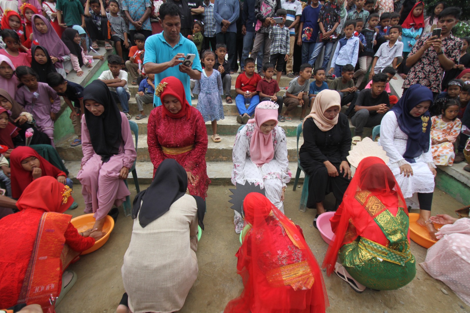 Keterangan Foto: Kegiatan membasuh kaki para ibu di Kampung Matfa yang dilakukan oleh anaknya masing - masing pada acara peringatan Hari Ibu Nasional, Sabtu (21/11/2024).