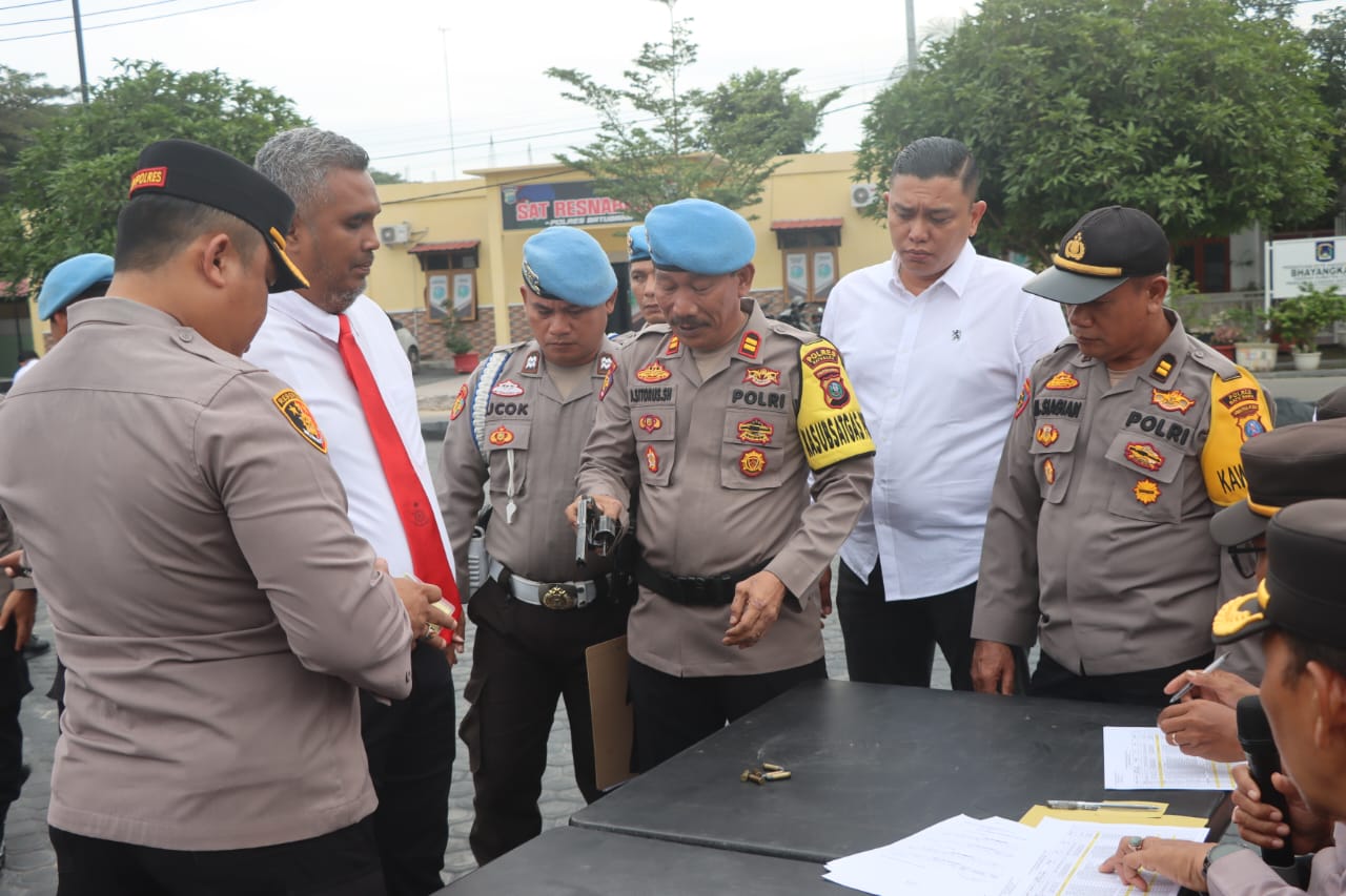 Teks fhoto Polres Batubara periksa senjata api (senpi) dinas dan amunisi Personil usai apel pagi di halaman Momo Polres Senin (23/12-2024).beritasore/alirsyah