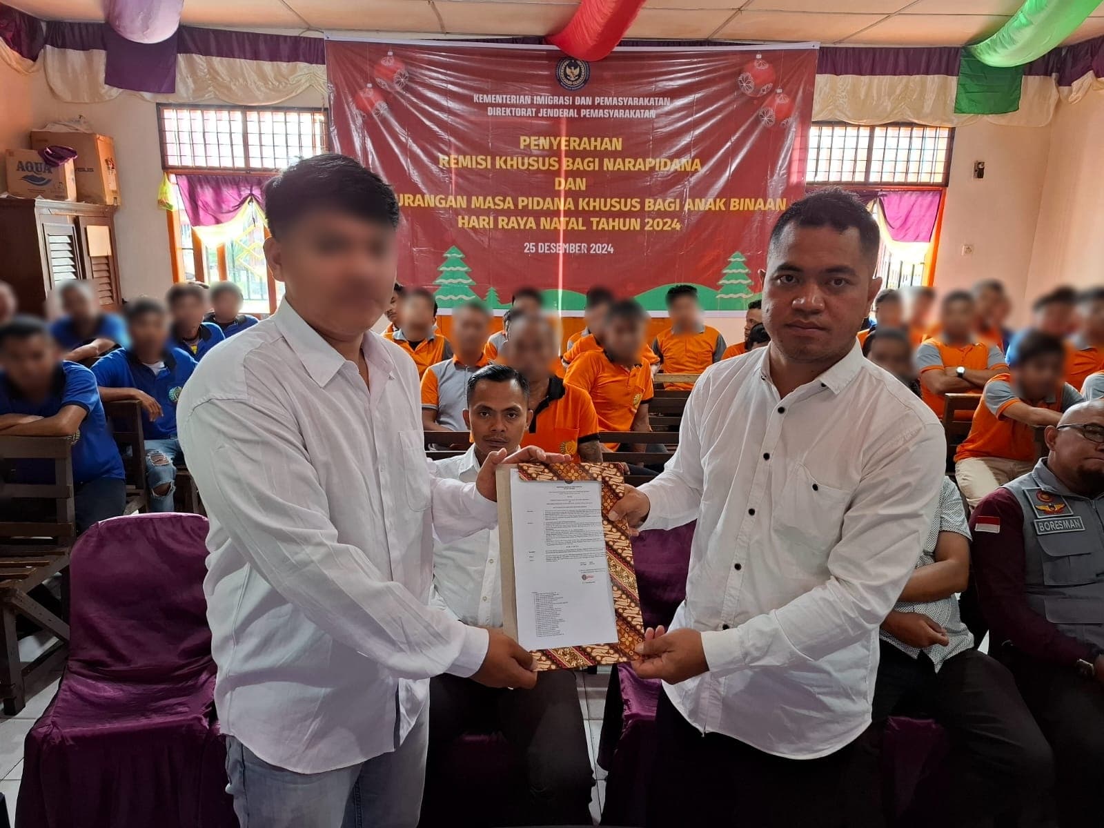 Keterangan Foto: Kasubsi Pelayanan Tahanan Rutan Tarutung, Jonias B.Pakpahan menyerahkan SK Remisi Khusus Natal Tahun 2024 secara simbolis kepada perwakilan narapidana di Aula Rutan Kelas IIB Tarutung, Rabu (25/12).(ist). 